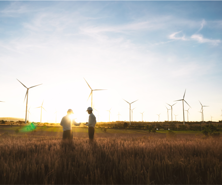 Two engineers on a field with wind turbines