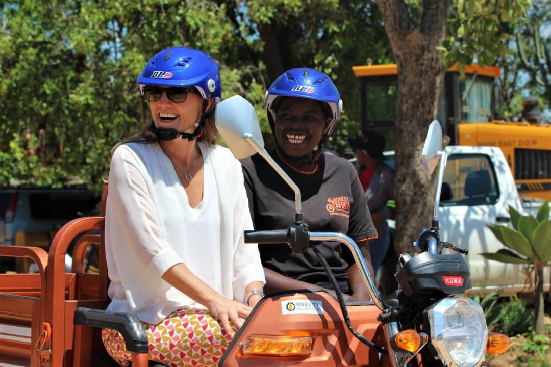 Two women with blue helmets on scooter